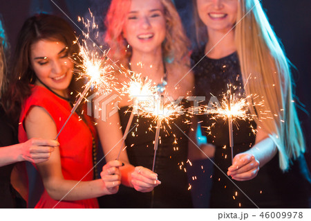 Celebrating with fun. Group of cheerful young women carrying sparklers. New year, holidays and party Celebrating with fun. Group of cheerful young women carrying sparklers. New year, holidays and party 46009978