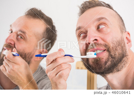 Man brushing his teeth in bathroom 46010641