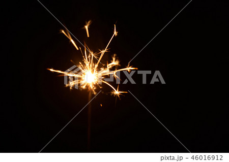 A burning sparkler on a black background isolated 46016912