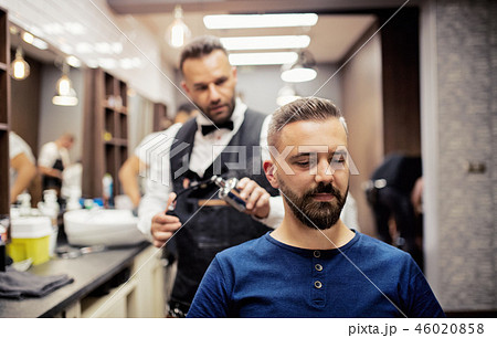 Hipster man client visiting haidresser and hairstylist in barber shop. 46020858