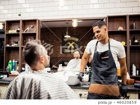 A man client talking to haidresser and hairstylist in barber shop. A man client talking to haidresser and hairstylist in barber shop. 46020859