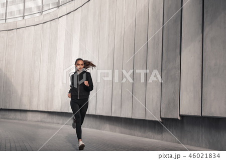Young athlete is running near the stadium. Young athlete is running near the stadium. 46021834