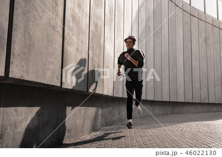 Young athlete is running near the stadium. 46022130
