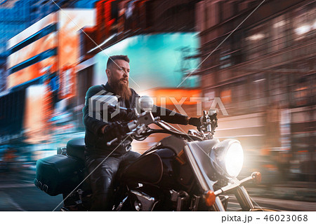 Biker riding on chopper through the night city Biker riding on chopper through the night city 46023068