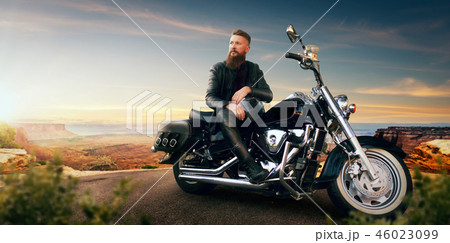 Biker sitting on his chopper and looks on sunset 46023099