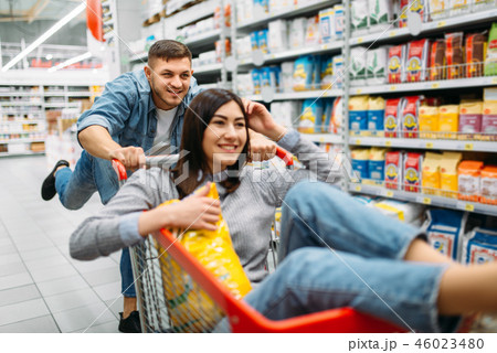 Husband carries his wife in the cart, supermarket Husband carries his wife in the cart, supermarket 46023480