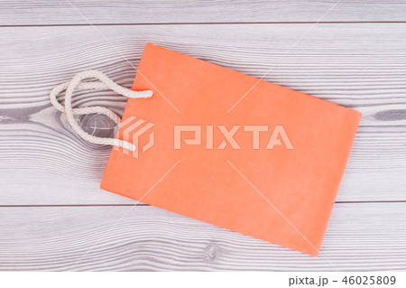 Blank orange shopping bag on wooden background. Blank orange shopping bag on wooden background. 46025809