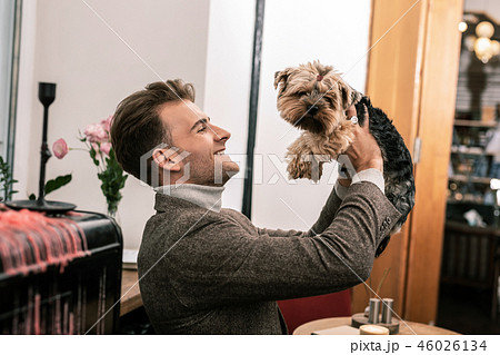 Man holding a little dog in his hands Man holding a little dog in his hands 46026134