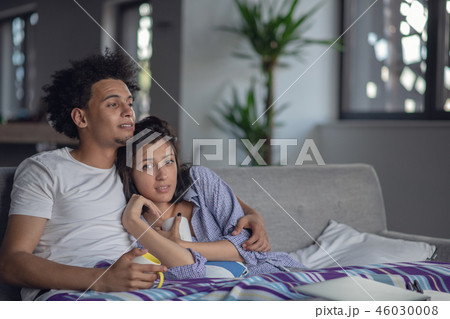 Young couple watching a movie on their laptop in bed 46030008