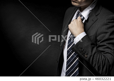 ネクタイを緩めるスーツ姿の男性の写真素材