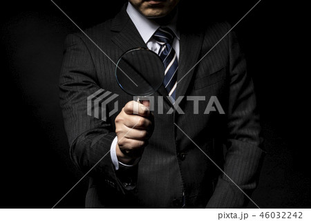 拡大鏡を手に持ったスーツ姿の男性 46032242