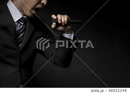 マイクを持って力説する男性 46032248