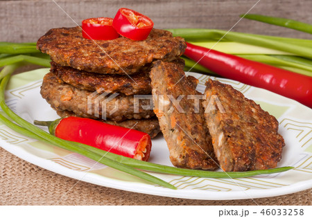 liver pancakes or cutlets with chili pepper and green onions on a wooden background liver pancakes or cutlets with chili pepper and green onions on a wooden background 46033258