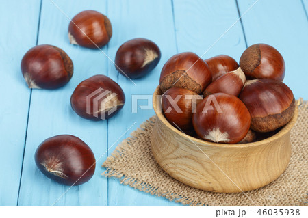 chestnut in wooden bowl on blue wooden background chestnut in wooden bowl on blue wooden background 46035938
