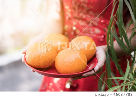 young Chinese woman holding oranges in red dress young Chinese woman holding oranges in red dress 46037788