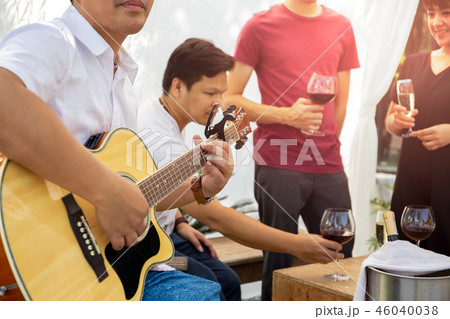 Group of friends having party with red wine and playing guitar outdoor. Group of friends having party with red wine and playing guitar outdoor. 46040038