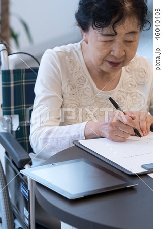 シニアイメージ 書類にサインをするシニア女性 シニアイメージ 書類にサインをするシニア女性 46040403