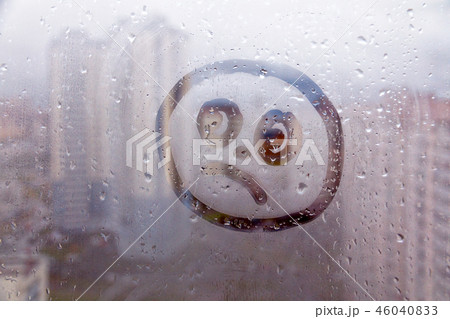 Foggy glass on window with drawn sad face concept photo Foggy glass on window with drawn sad face concept photo 46040833