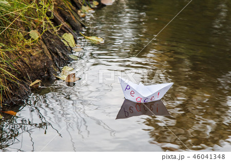 white paper boat called peace floating on a stream white paper boat called peace floating on a stream 46041348