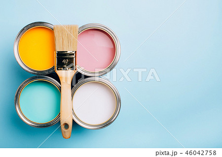 Brush with wooden handle on open cans on blue pastel background. 46042758