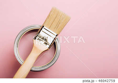 Brush with wooden handle on open can of pink paint on pastel background. Brush with wooden handle on open can of pink paint on pastel background. 46042759