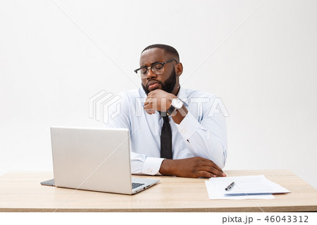 Irritated dark skinned young male enterpreneur being on working place feels very stressed and angry Irritated dark skinned young male enterpreneur being on working place feels very stressed and angry 46043312