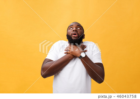 Portrait of african american man with hands raised in shock and disbelief. Isolated over yellow 46043758