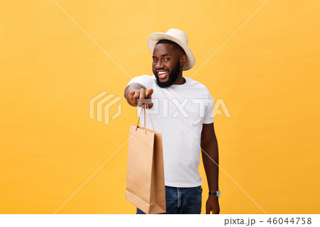 African American man with colorful paper bags isolated on yellow background 46044758
