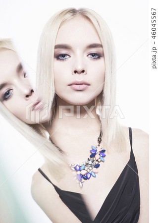 Beautiful young blonde in classic black dress and modern jewelry 46045567