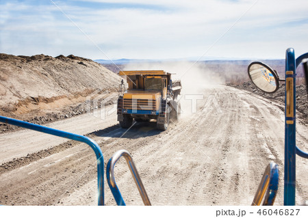 Old yellow dump truck moving in a mine 46046827