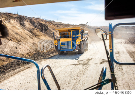 Yellow dump truck moving in a mine 46046830
