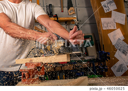 A carpenter works on woodworking the machine tool. Saws furniture details with a circular saw A carpenter works on woodworking the machine tool. Saws furniture details with a circular saw 46050025