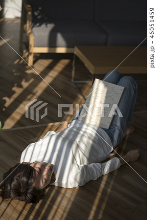 ブラインド越しの明かりで読書を楽しむ女性 ブラインド越しの明かりで読書を楽しむ女性 46051459