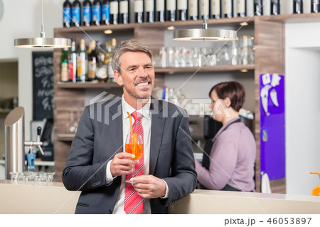 Man holding cocktail near the bar counter Man holding cocktail near the bar counter 46053897