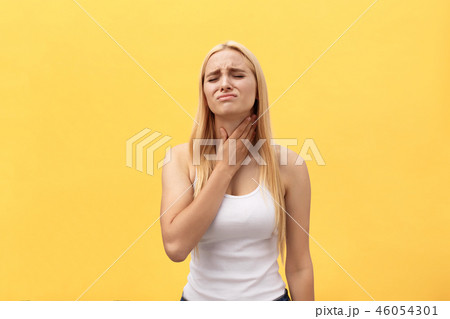 Tired young caucasian woman having pan in neck. Isolated over yellow background. 46054301