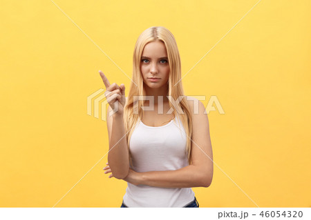 Woman showing pointing on yellow background. Very fresh and energetic beautiful young girl smiling Woman showing pointing on yellow background. Very fresh and energetic beautiful young girl smiling 46054320