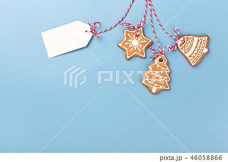 Gingerbread cookies hanging over blue background Gingerbread cookies hanging over blue background 46058866