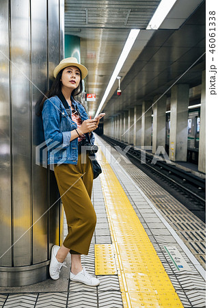 tourist holding cellphone standing on platform tourist holding cellphone standing on platform 46061338