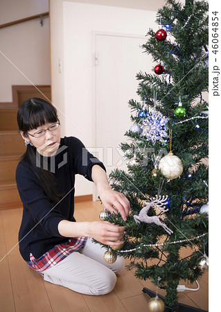 クリスマスツリーの飾り付けをする母親 46064854