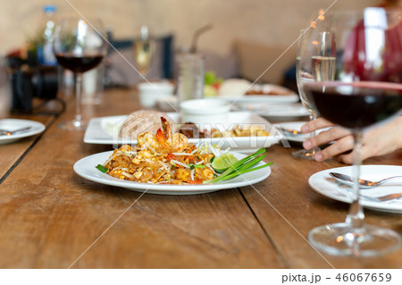 Famous Pad Thai noodles with shrimps and glass of red wine on wooden table. Famous Pad Thai noodles with shrimps and glass of red wine on wooden table. 46067659