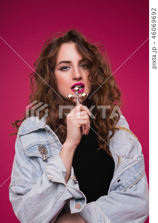 Curly brunette in jeans jacket and gold cross view Curly brunette in jeans jacket and gold cross view 46069692