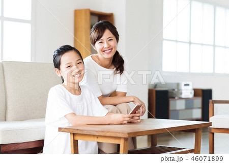 家族　親子　ファミリー　女性　スマホ　リビング 46071899