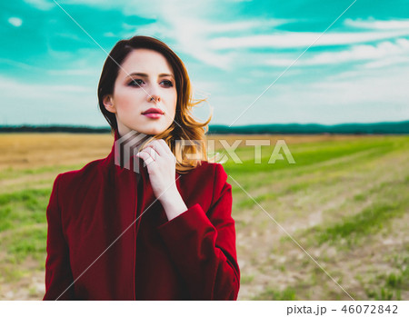 Woman in red coat at countryside field  46072842