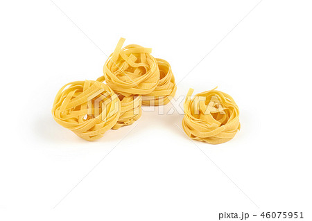 Uncooked nest of tagliatelle pasta isolated on white background. 46075951