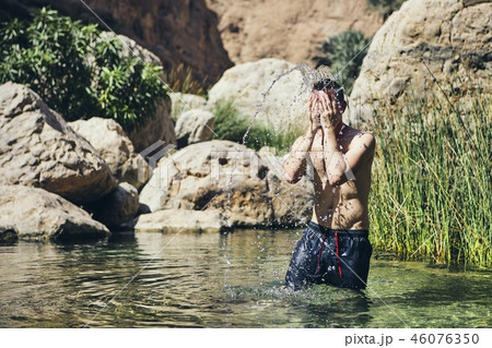 Young man splashing water on face 46076350