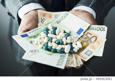 businessman with a pile of pills and euro bills 46082681