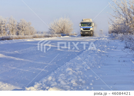 Convoy of heavy trucks drives along a snowy road Convoy of heavy trucks drives along a snowy road 46084421