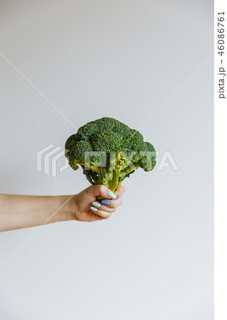 Woman Hand holding raw broccoli cabbage florets infront of white background. Heathy lifstyle concept Woman Hand holding raw broccoli cabbage florets infront of white background. Heathy lifstyle concept 46086761
