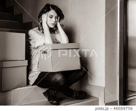 woman with moving boxes sitting on stairs in house woman with moving boxes sitting on stairs in house 46089756