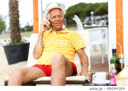 Positive mature man sitting and speaking phone 46094164